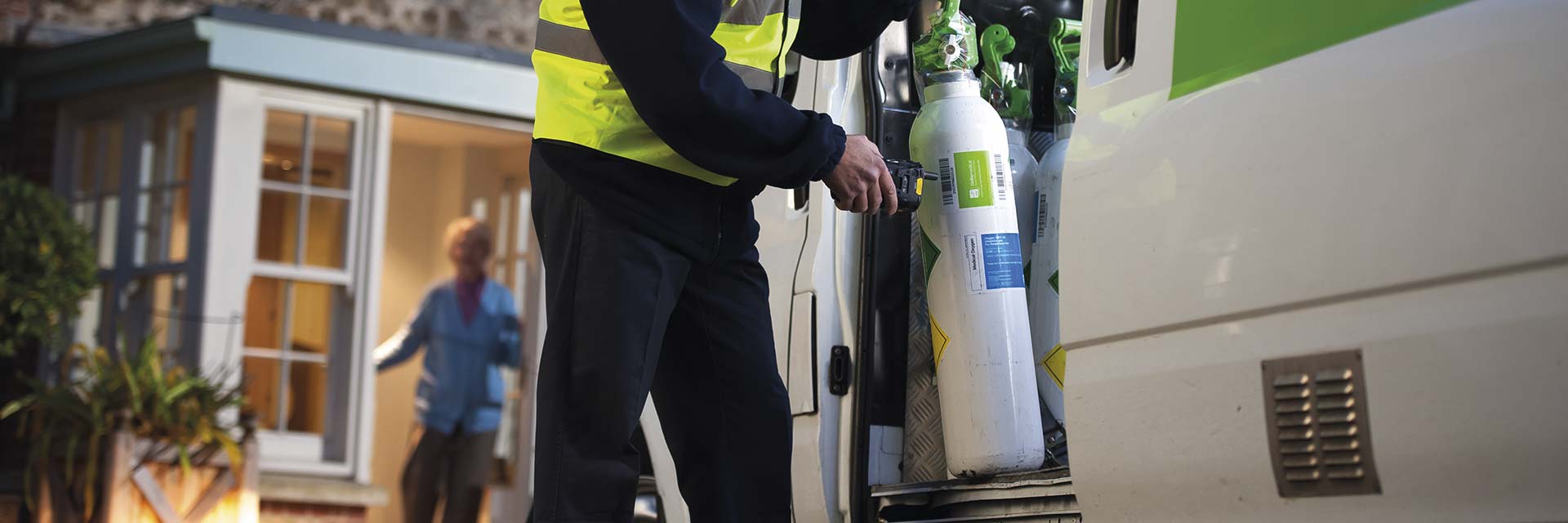 Technician scanning oxygen cylinder before delivering to a patient at home